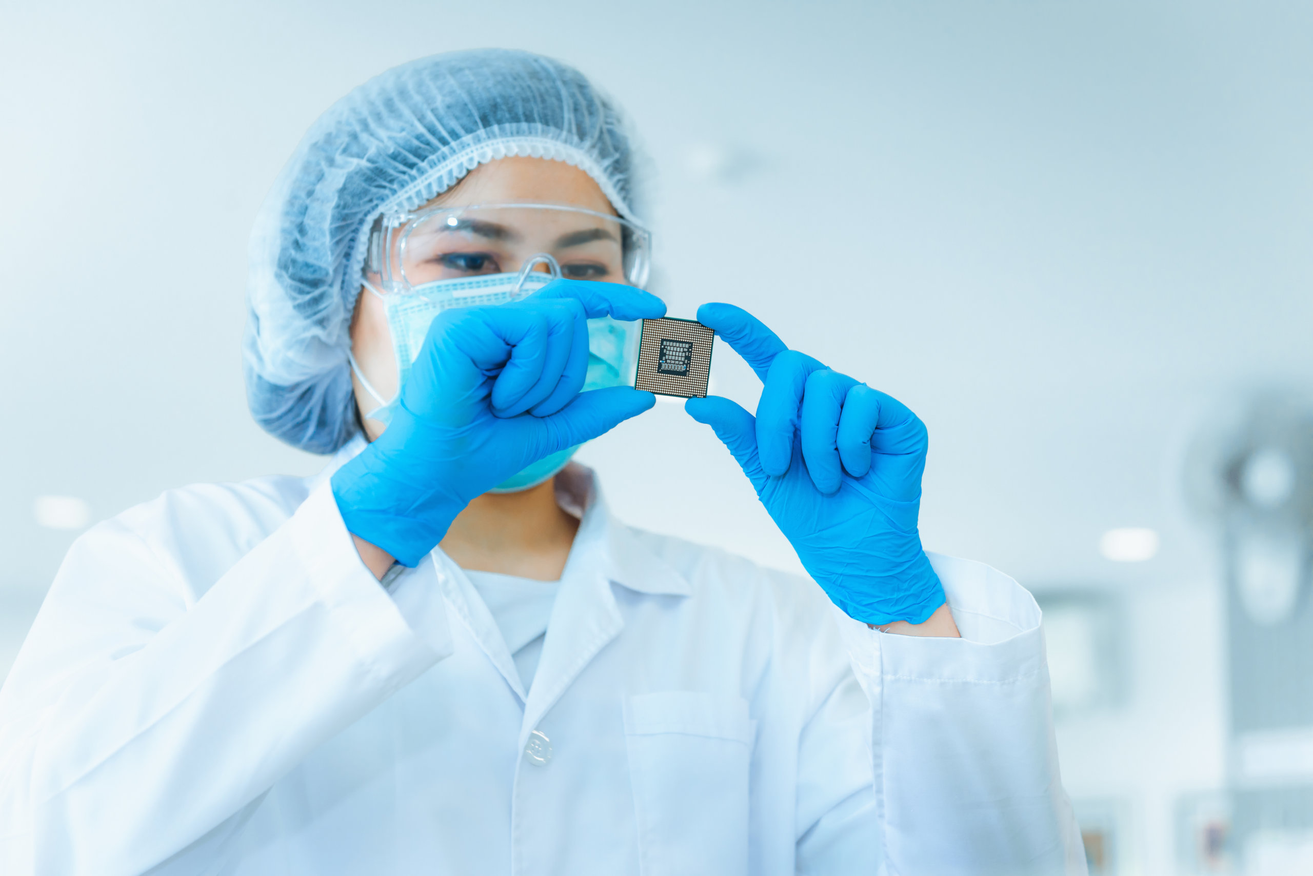 woman inspecting chip after IC Packaging and assembly 